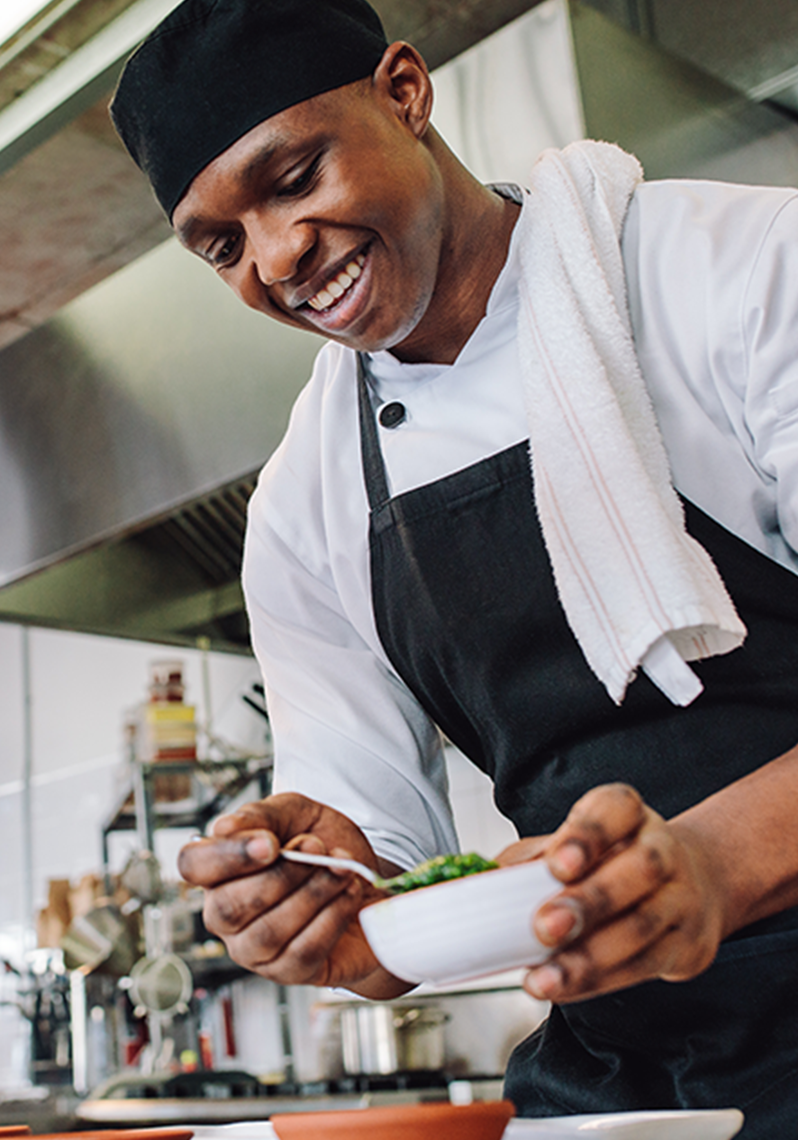 Gourmet chef in uniform cooking in a commercial kitchen.